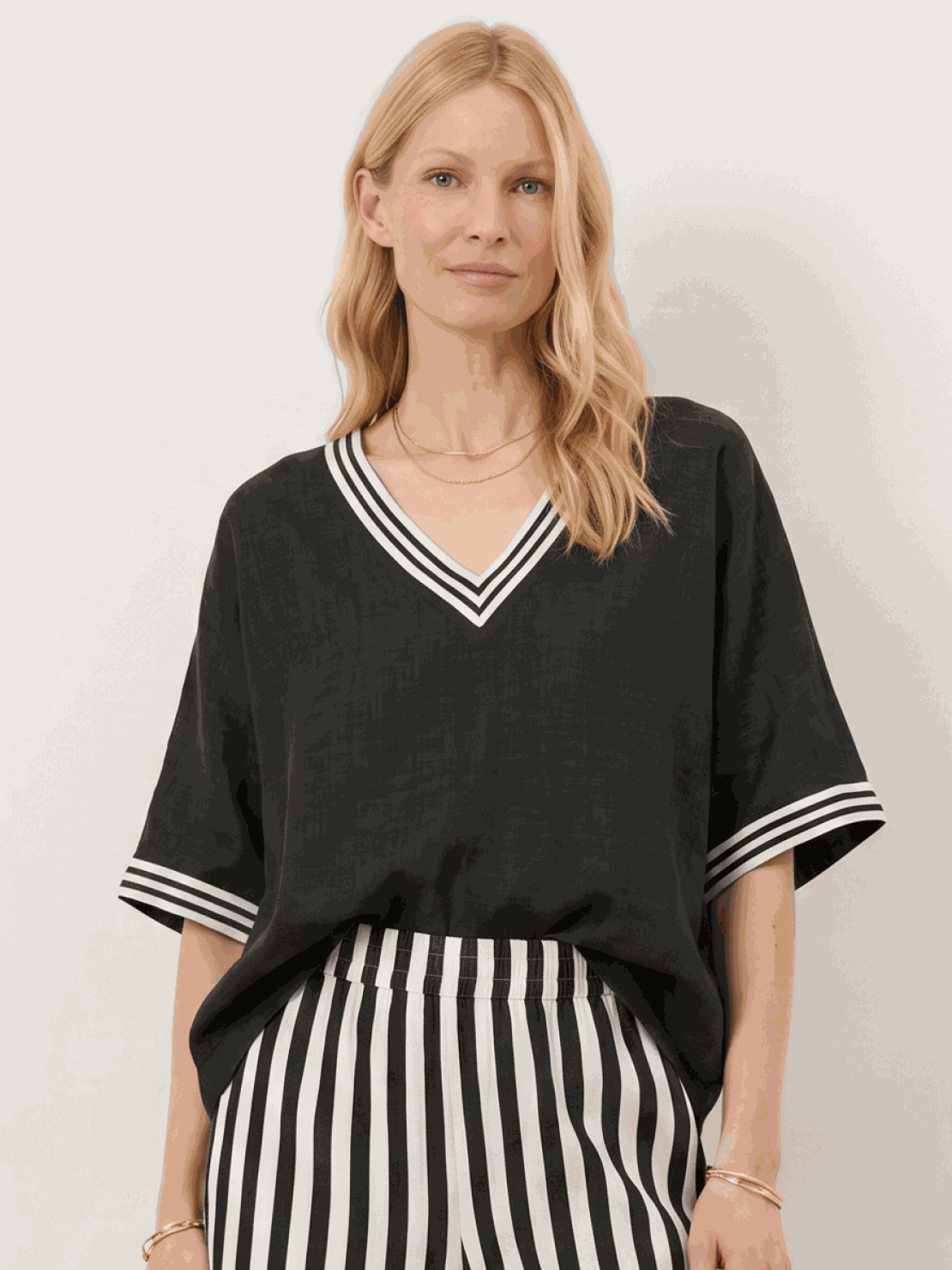 Woman wearing striped wide-leg co-ord set with oversized top and palazzo pants with contrast stripe trim and side pockets