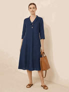 Woman wearing navy linen-look midi dress with relaxed fit and button detail