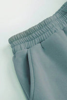 Woman wearing a comfortable cotton-blended two-piece tracksuit with high collar and deep zipper in monochrome design