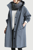 Water resistant oversized windbreaker rain jacket with hood and button closure in grey color