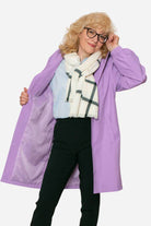 Woman wearing purple water resistant oversized windbreaker with scarf and glasses