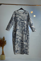 Japanese Porcelain Print cozy midi dress with blue motif, 3/4 sleeves, and functional pockets hanging on wooden rod.