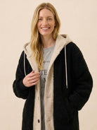 Woman wearing black and beige cozy oversized sherpa long coat with hood, perfect everyday wear oversized coat for warmth and style