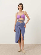 Gold-detail cutout one-piece swimsuit with ruched panels and gold dome accent, paired with midi wrap skirt beach cover-up