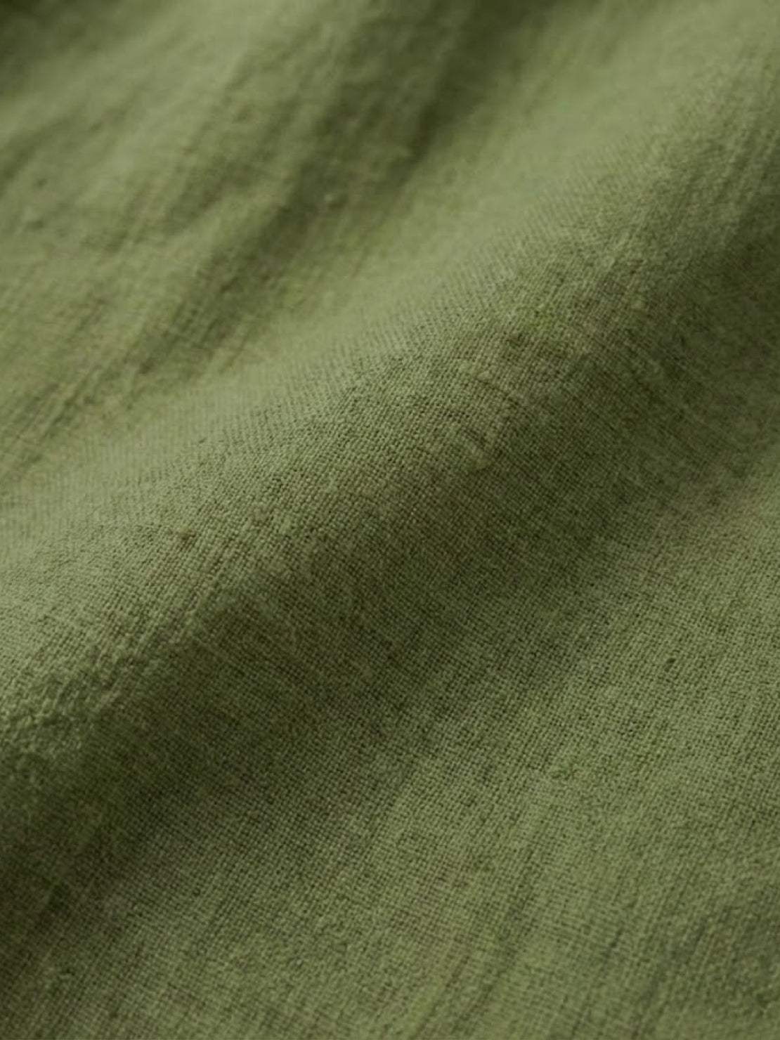 Close-up of soft green pure linen fabric texture for age-defying shirt