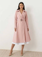 Woman wearing water-repellent A-line hooded raincoat with belt in light pink