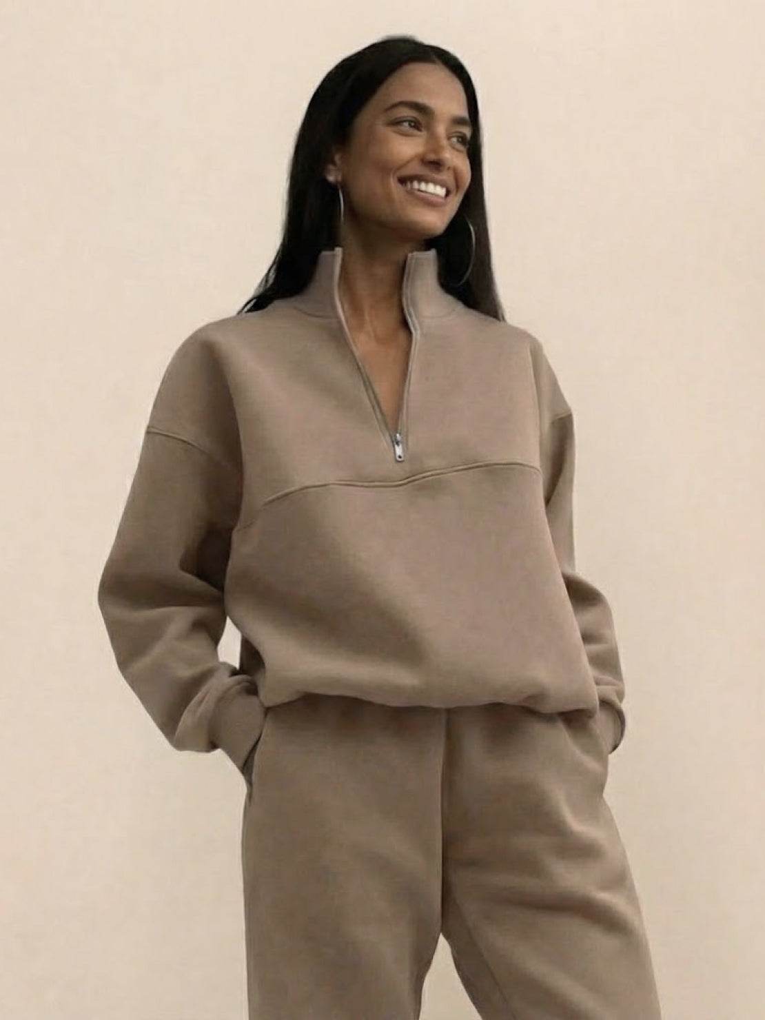 Woman wearing cotton-blended two-piece tracksuit with high collar and deep zipper in casual athleisure style