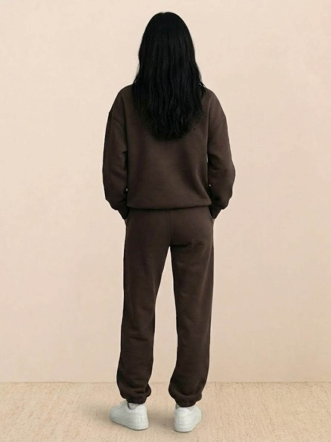 Woman wearing a cotton-blended two-piece tracksuit with high collar and zipper in a casual athleisure style