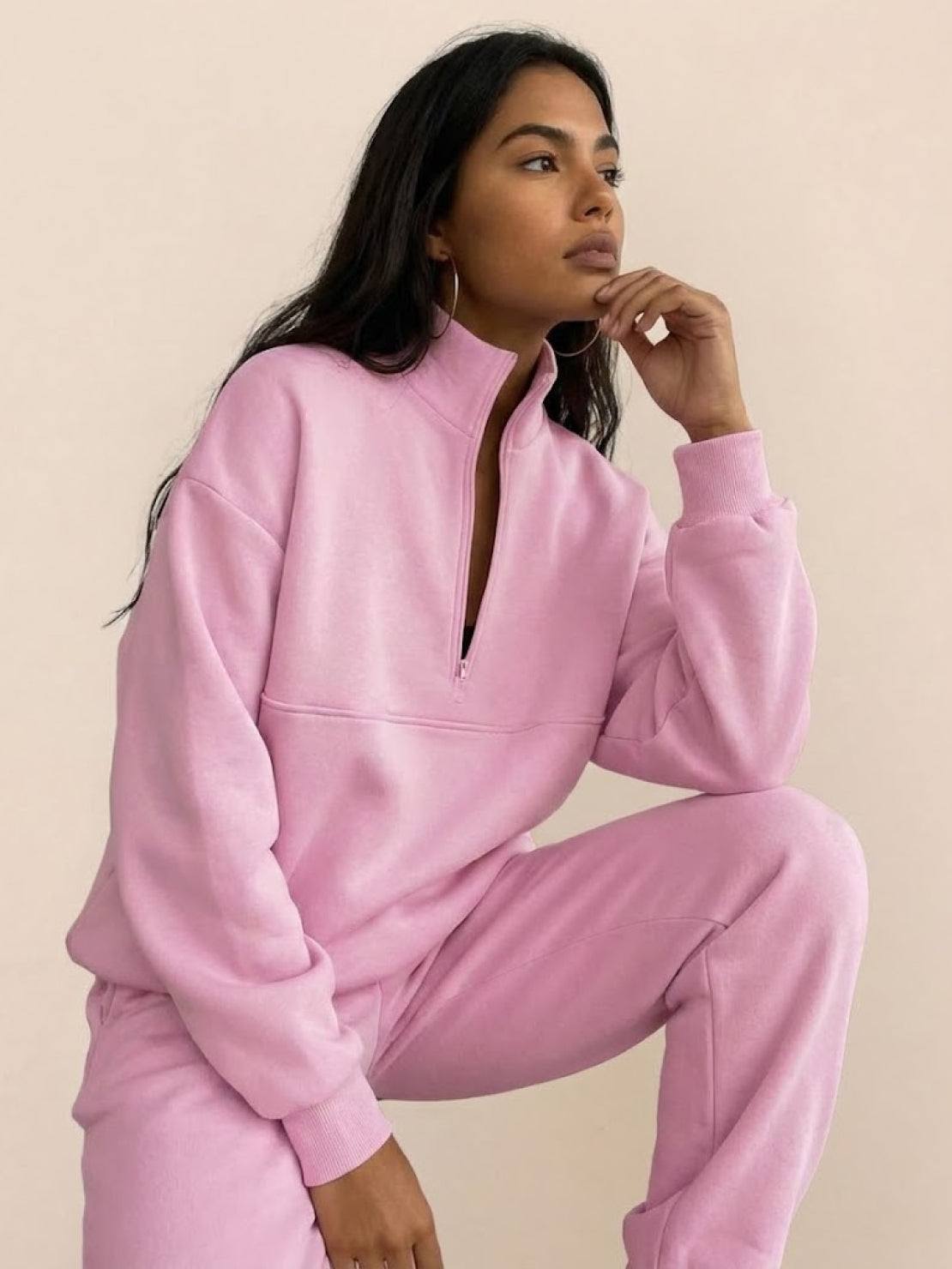 woman wearing cotton-blended two-piece tracksuit with high collar and zipper, showcasing athleisure style