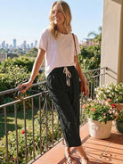 Woman wearing breezy relaxed fit straight pants in blue standing outdoors with hands in pockets