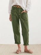 Woman wearing casual button-down utility-chic trousers with deep pockets and rolled cuffs