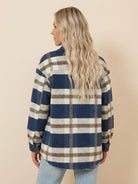Woman wearing a blue and beige plaid comfy flannel classic button-down shirt seen from the back