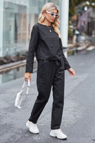 Woman wearing black cotton-linen monochrome capsule set with longline top and wide-leg pants walking on street