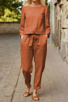 Woman wearing rust-colored cotton-linen monochrome longline top and wide-leg pants set with relaxed fit and tie waist