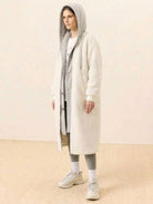 Woman wearing a cozy, oversized sherpa long coat with hood, perfect for everyday wear oversized coat, styled with casual athleisure outfit
