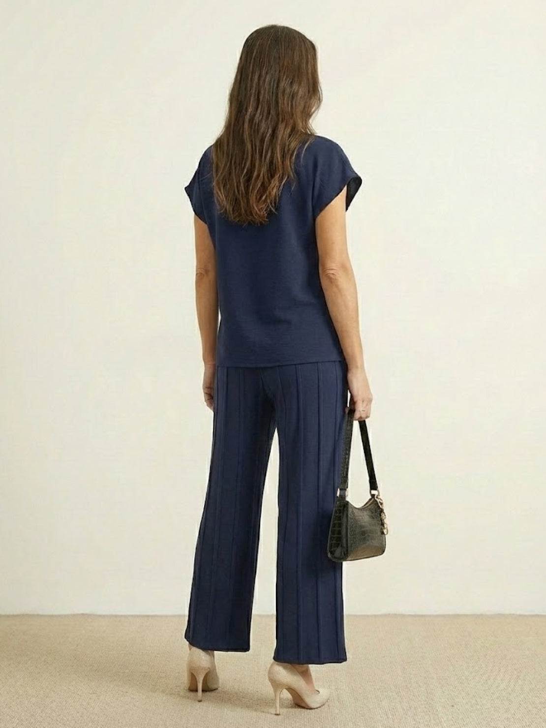 Woman wearing First Class Travel comfort two-piece set in pleated design with wide-leg pants and matching top