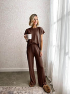 Woman in a wrinkle-resistant, breathable two-piece set designed for first class travel comfort and elegance