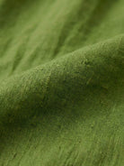 Green loose solid color linen-feel fabric close-up for breathable two-piece set