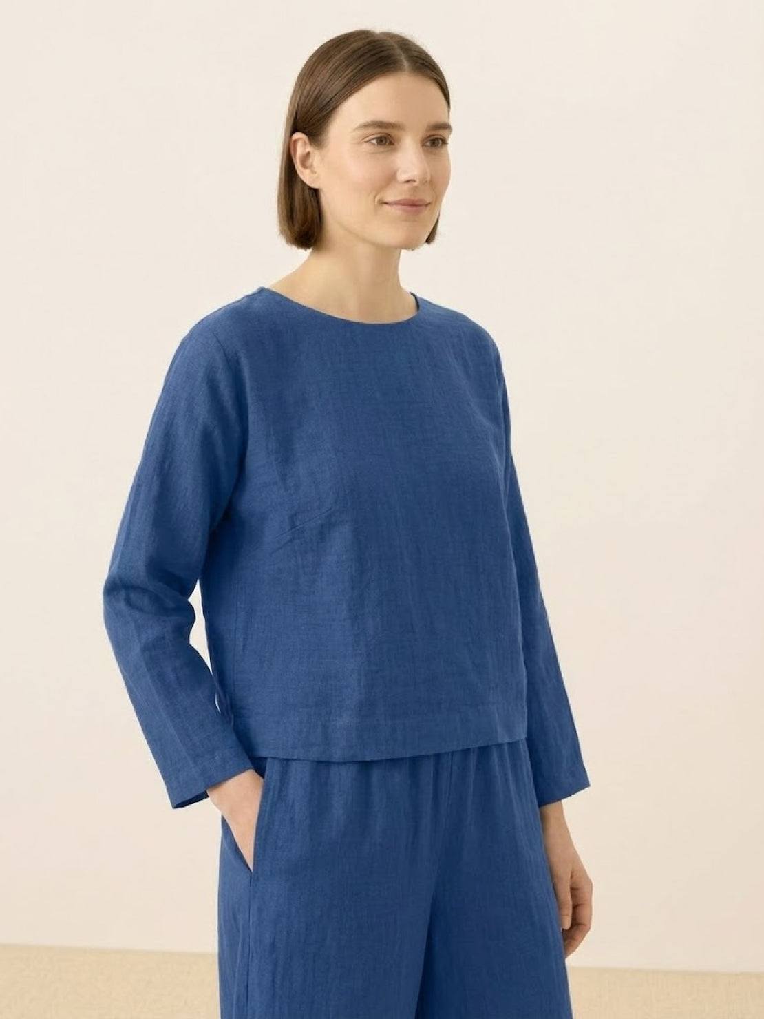 woman wearing blue loose solid color two-piece set with long sleeves and wide-leg pants
