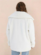 Back view of a white open front oversized faux fur jacket with a draped shawl collar worn by a model