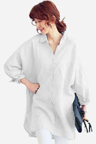 Woman wearing oversized white linen shirt with relaxed fit and button-down front