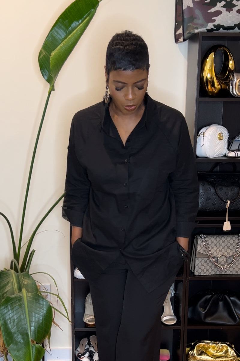 Black oversized linen shirt with relaxed fit and button front worn by woman indoors