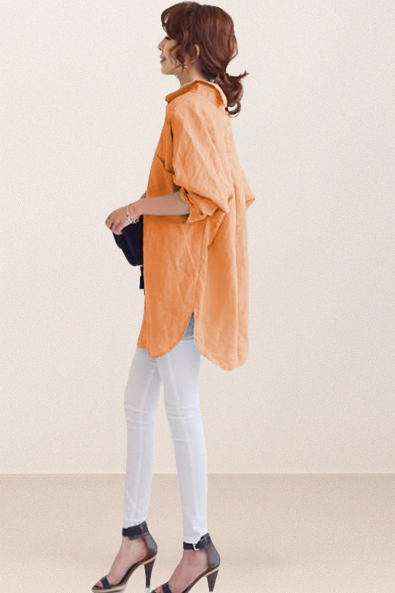 Side view of woman wearing oversized linen shirt in soft orange with white pants and black heels