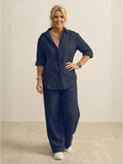 woman wearing oversized 100% cotton navy blue shirt and wide-leg pants co-ord set standing against plain background