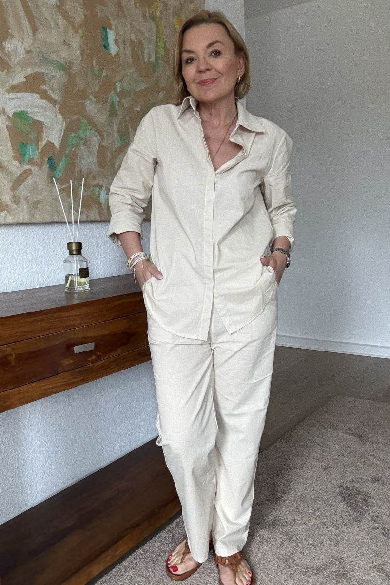 Woman wearing oversized 100% cotton shirt and wide-leg pants co-ord set in neutral tone indoors