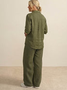 Back view of model wearing oversized 100% cotton olive green shirt and wide-leg pants co-ord set