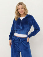 woman wearing modern cropped velour hoodie and high-waist velour pants tracksuit set