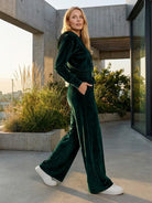 Woman wearing modern cropped velour tracksuit with high-waist pants in soft polyester fabric