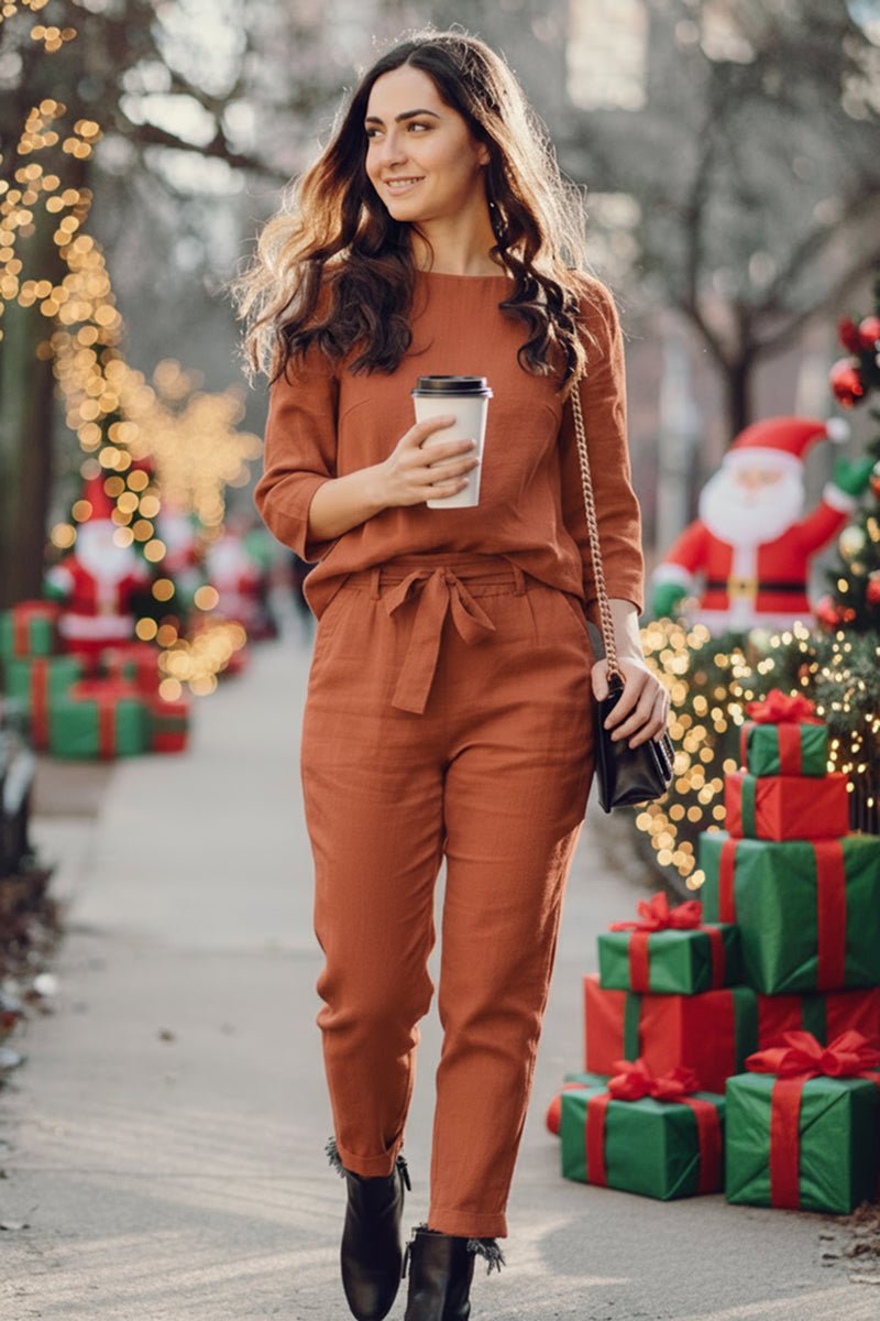 Woman wearing retro monochrome linen two-piece set walking near Christmas decorations holding coffee cup