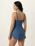 Woman wearing ruched wrap one-piece swimdress with side ruching and adjustable straps on beach