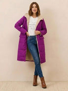 Woman wearing purple Sherpa-lined hooded teddy coat with front pockets, paired with jeans and brown ankle boots.