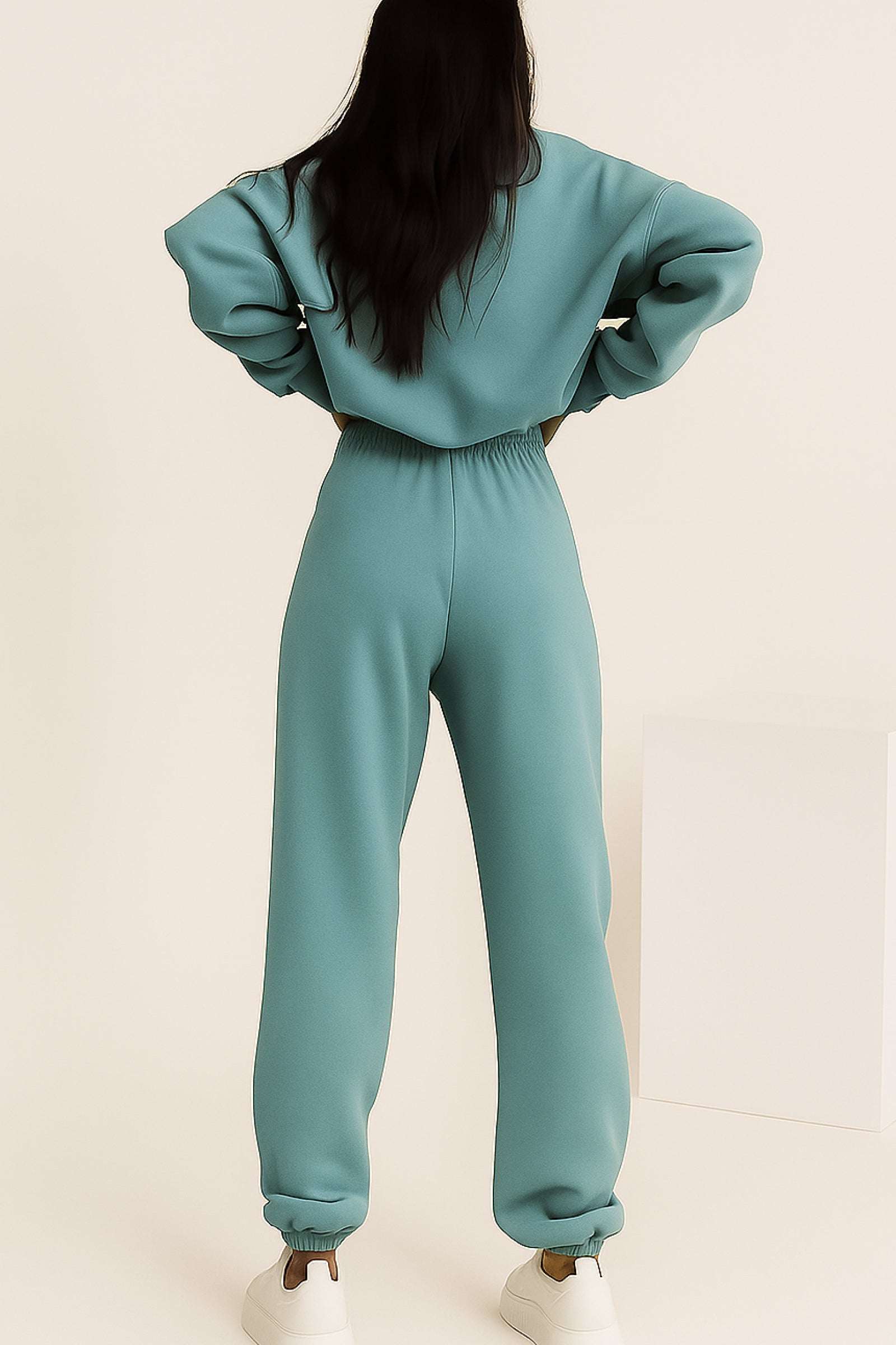 Woman wearing mint green cotton blend tracksuit with elastic cuffs, seen from back
