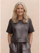 Woman wearing a loose fit co-ord set with relaxed top and wide-leg bottoms in neutral tones