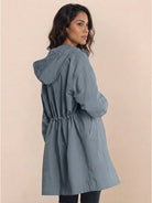 Woman wearing gray oversized Rain Couture Windbreaker jacket with hood, back view