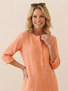 woman wearing orange lightweight cotton dress with 3/4 sleeves and button-up front