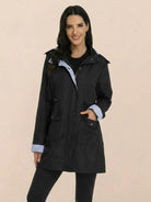 woman wearing black water resistant hooded striped windbreaker rain jacket with pockets